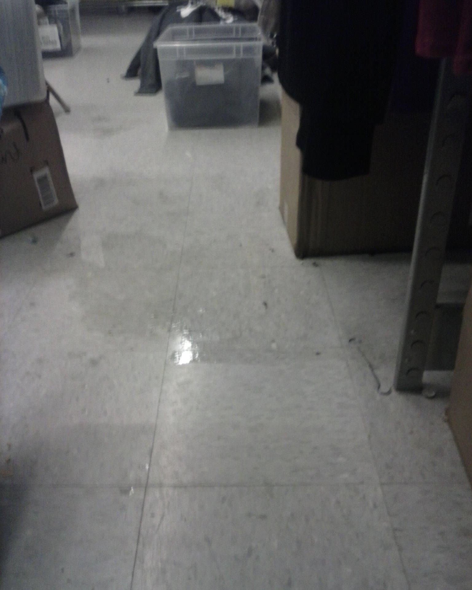 A puddle of water on a stock room tile floor at the Vancouver Mall.