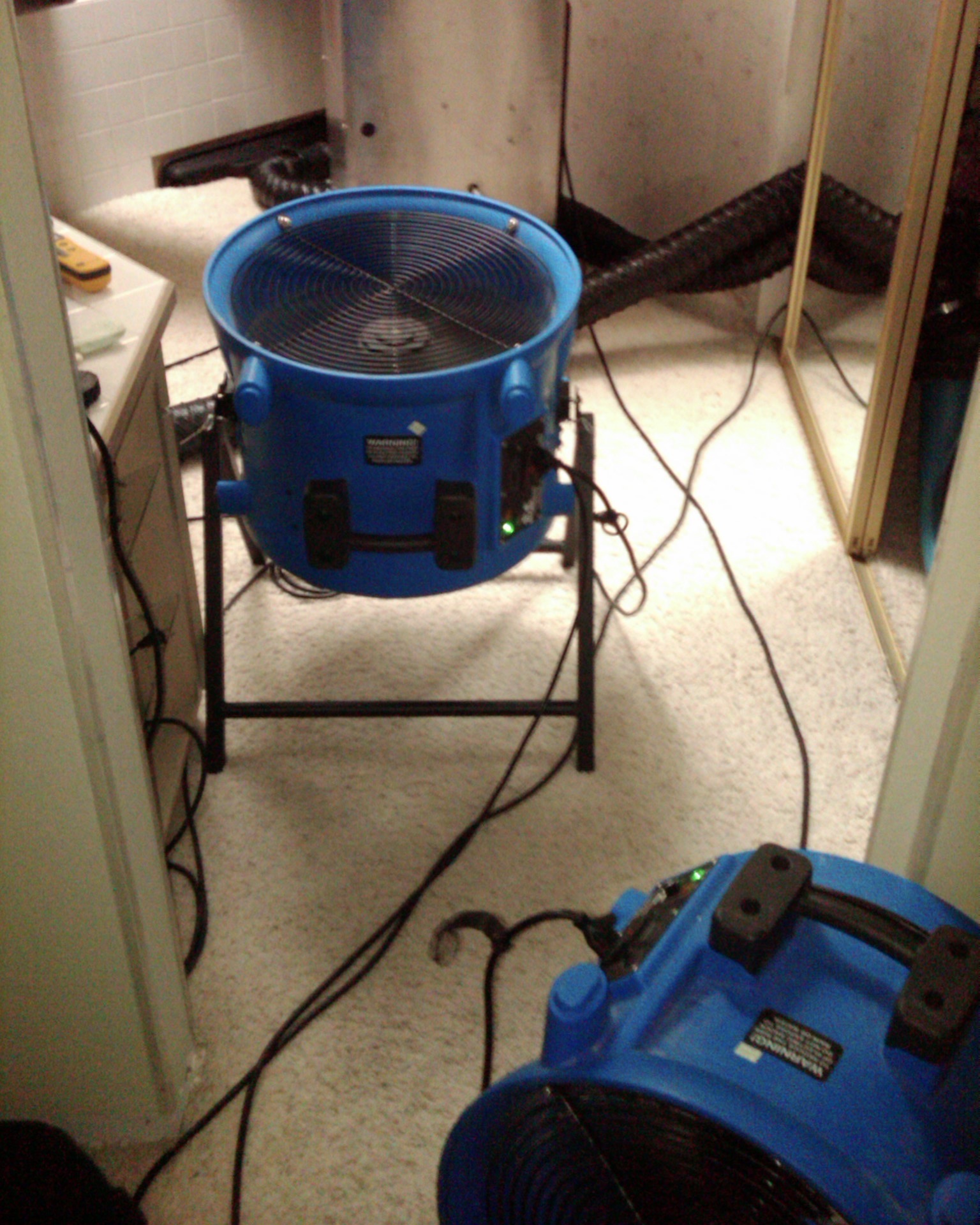 Two blue axial fans and a wall drying system in use at a water damage in the Cascade South East neighborhood of Vancouver WA at 3111 Se Balboa Dr Vancouver, WA 98683