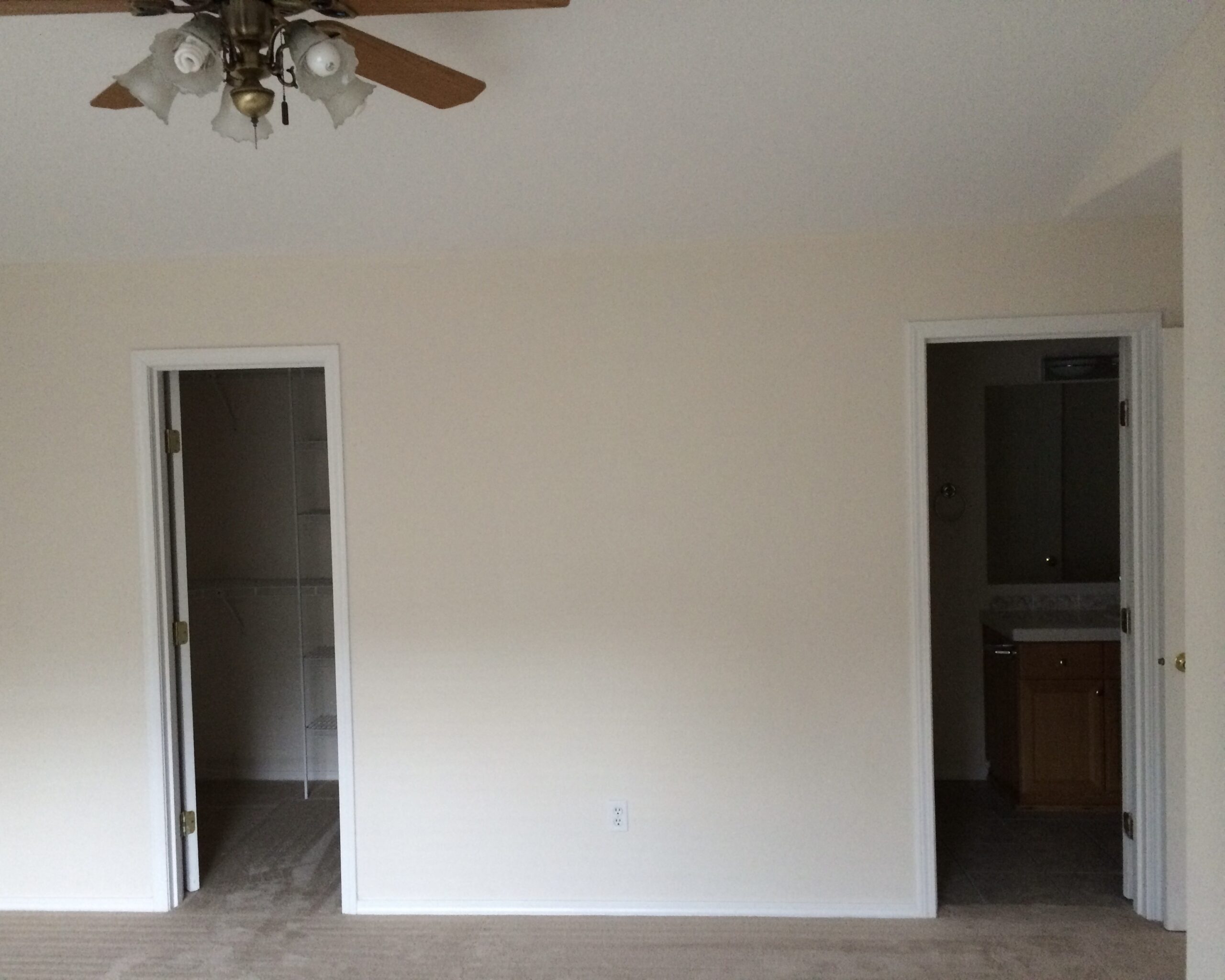 Image of a fully restored bedroom with cream colored walls and white ceiling and 2 doors in Salmon creek Washington